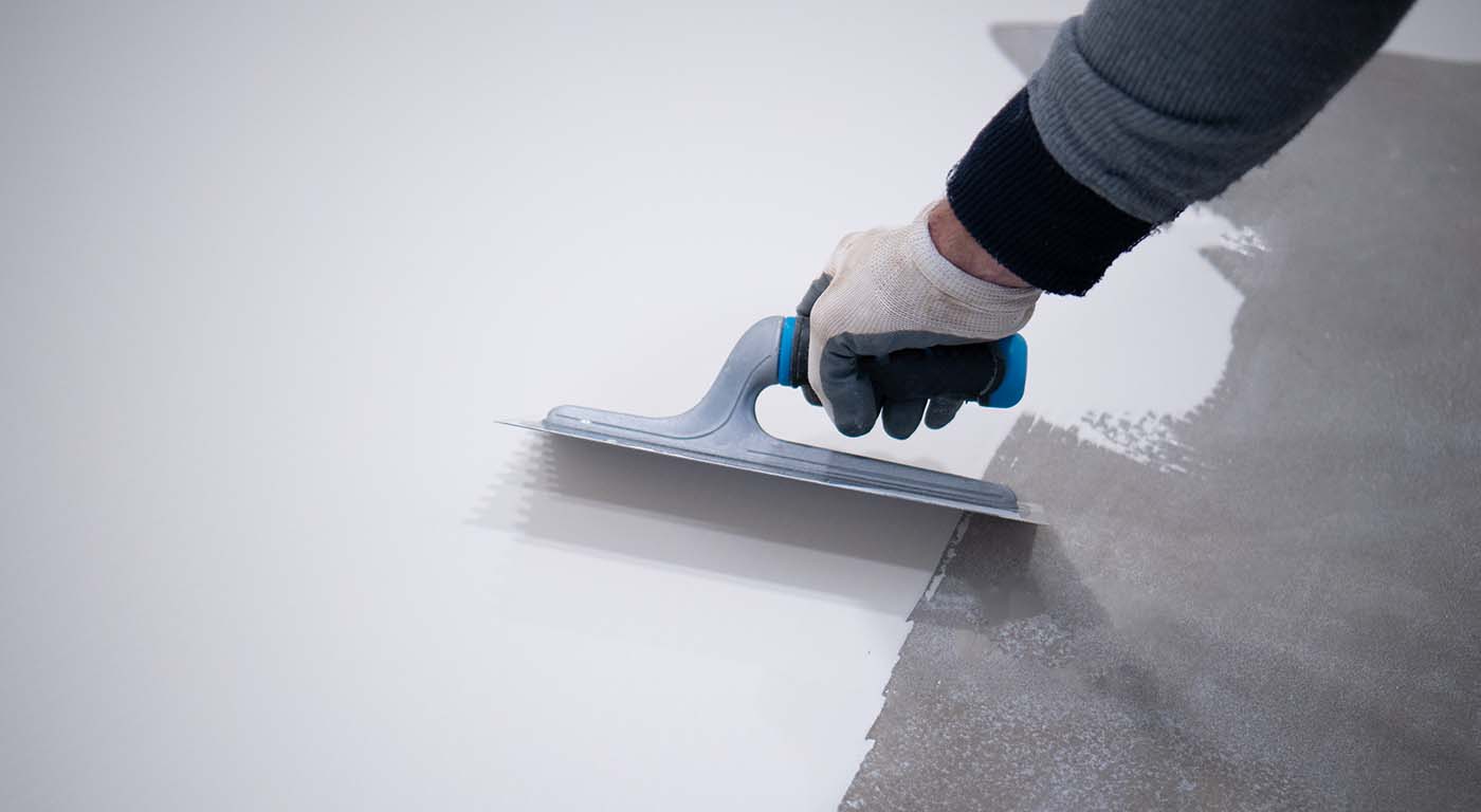 Worker,Applying,A,White,Epoxy,Resin,Bucket,On,Floor